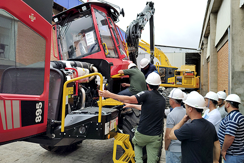 Turma da Komatsu School em aula prática ao redor de um forwarder Komatsu 895